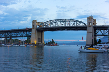 Burrard Bridge at dawn in Vancouver, British Columbia, Canada. Steel truss bridge over False Creek with imposing concrete towers before sunrise.