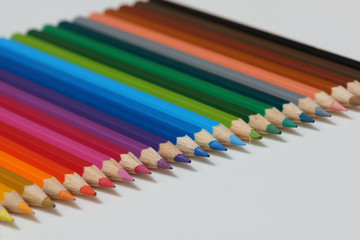 Selective focus of pencil colours on near-white chopping board