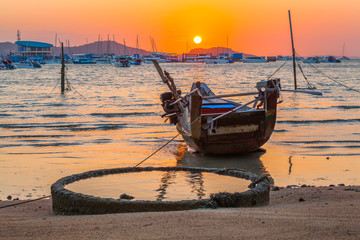 red sky in the morning at Chalong gulf.a small fishing boat park on the shore