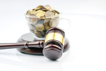Wood gavel and coins with white background.
