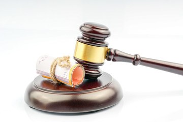 Wood gavel and coins with white background.
