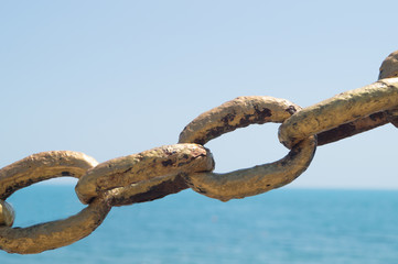 Old metal chain on beach background in the sunlight