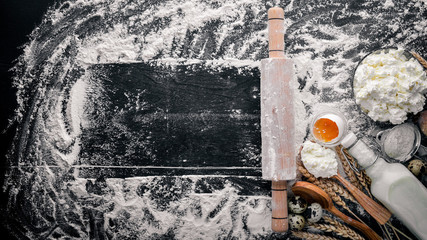 Preparation for baking, cheese sour cream, milk, flour, eggs. On a black wooden background. Top view. Free space.