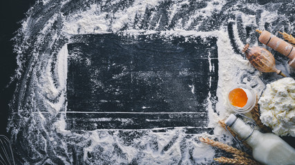 Preparation for baking, cheese sour cream, milk, flour, eggs. On a black wooden background. Top view. Free space.