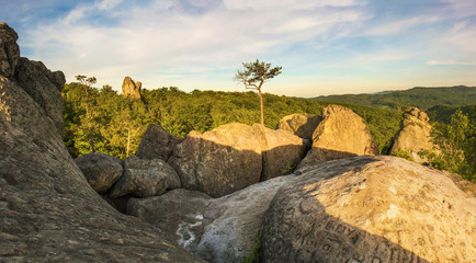The last rays of the setting sun illuminate the rocks of Dovbush in the Carpathians