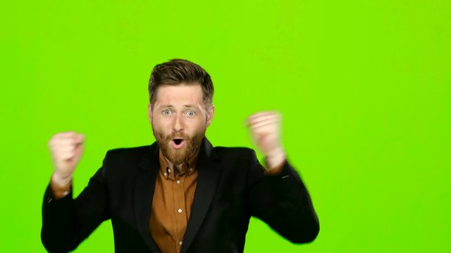 Young guy is happy with his victories, he is happy. Green screen