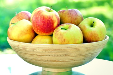 Organic apples in basket on table. Fresh apples in nature.
