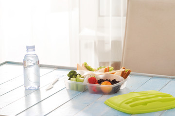 Full lunch box of healthy food on wooden table