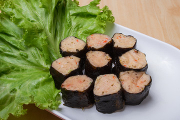 Steamed shrimp Wrapped with Green vegetable on white plate, Components used in making shabu or Sukiyaki and turn over the meat.