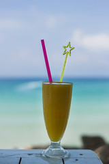 Orange cocktail near the ocean at sunny day