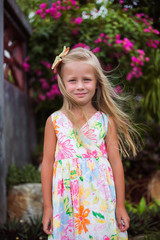 nice beautiful girl with long hair on vacation next to the flowering bushes in the tropics