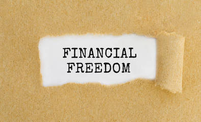Text Financial Freedom appearing behind ripped brown paper