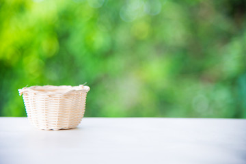 Fototapeta na wymiar Basket on wooden desk in garden and free space