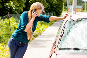 Woman dialing her phone after car crash