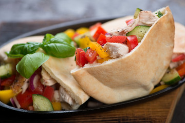 Close-up of pitas with grilled chicken meat and fresh vegetables, selective focus, shallow depth of field