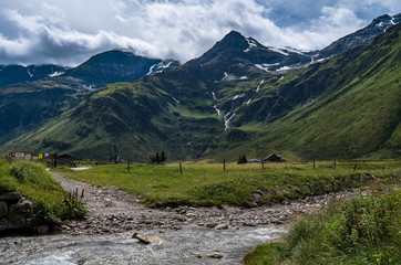 Fototapeta na wymiar Nassfeld mountan valley in Tyrol Austria during the day time small river is crossing the hiking trail