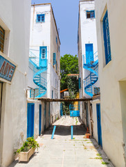NICOSIA, CYPRUS.View on the narrow street and white houses with blue iron helical stairs'