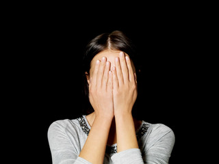 Young woman covering her face with her hands