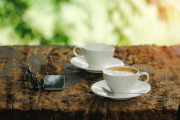 Stock Photo - Coffee mug with mobile phone and glasses on wooden table