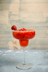 Cocktail strawberry margarita on the wooden background. Selective focus.