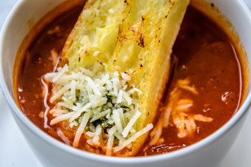 italian minestrone soup with garlic bread and grated cheddar cheese