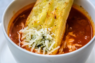italian minestrone soup with garlic bread and grated cheddar cheese