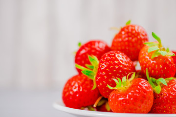 strawberries in bowl on wooden table with low key and copy space
