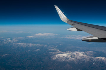 Wingtip of aircraft in flight feature the winglet with mountain in background