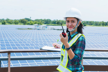 women engineer checking solar panel in routine operation  at solar power plant
