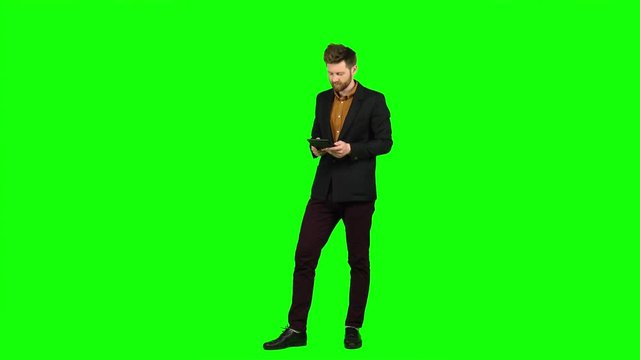 Man considers money on a calculator and is happy that he has income. Green screen