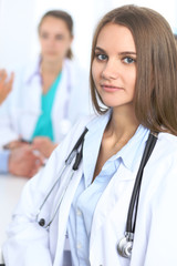 Happy doctor woman  with medical staff at the hospital sitting at the table