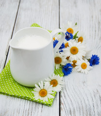 Obraz na płótnie Canvas jug with milk and wildflower