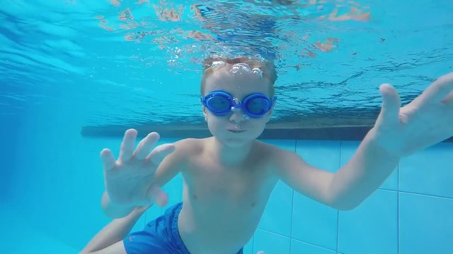 Boy Dives Under the Water in a Swimpool