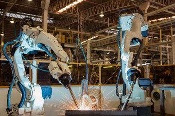 Robots are welding in car factory
