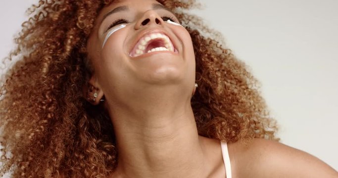 black mixed race blondie woman laughing at camera