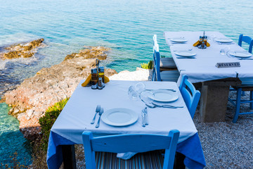 Empty tables of the restaurant on a cliff with an inscription reserved