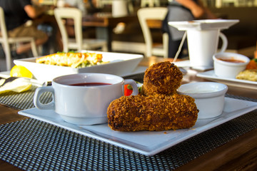 Golden croquettes with filling, borscht and tomatoes