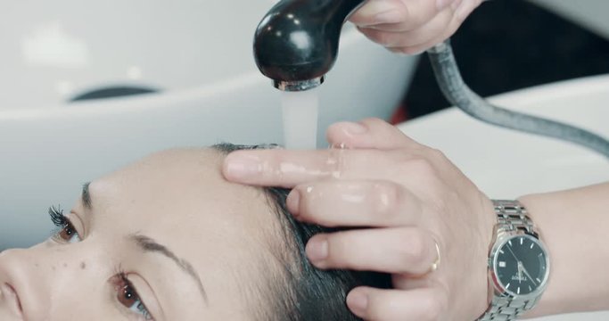 caucasian woman in salon has a hair treatment with professional hair dresser.