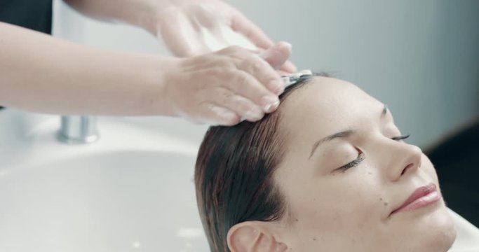 caucasian woman in salon has a hair treatment with professional hair dresser.