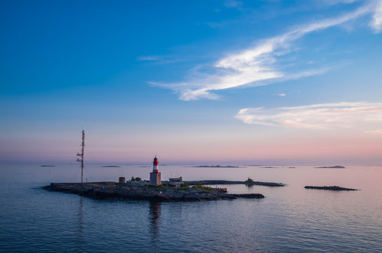 Pink sunset over the small island with a lighthouse near Helsinki Finland