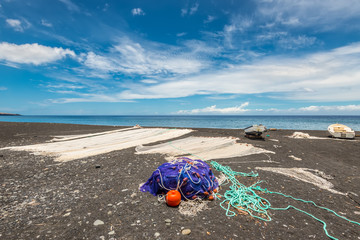 Fishing nets drying on the black beach