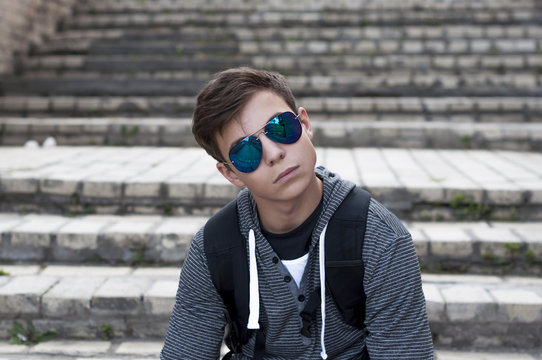 Young man sitting on the stairs on the city street