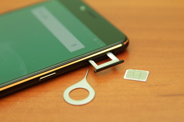 Black smartphone lying on a wooden table
