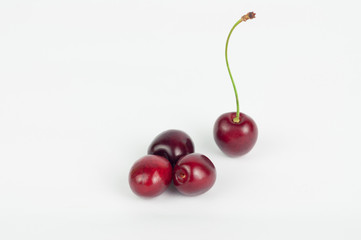 Four red fresh cherries on white background