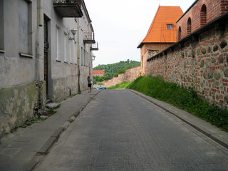 Fototapeta na wymiar Road in Vilnius, old brick wall, old house