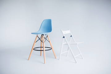 New modern chairs in white and blue standing in white room.