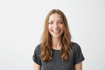 Young cheerful happy girl smiling laughing looking at camera over white background.