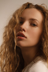 Beautiful girl portrait in studio with curly hair