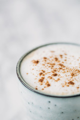 Cappuccino in a rustic style mug on a marble table