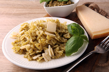 Farfalle pasta bows with pesto on a plate on a rustic background